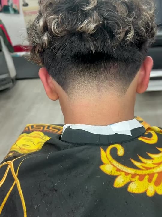 Blonde tipped curls over a clean taper